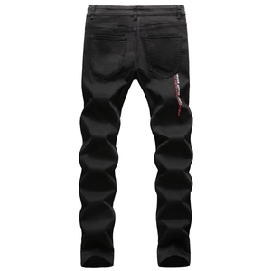 Vue détaillée du jean slim noir avec broderie blanche et rouge sur la poche arrière