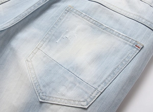 Détail de la poche arrière du short en jean bleu clair avec délavage et coutures rouges