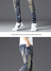 Detailed macro view of vintage wash jeans with distressed whiskers and zipper pockets