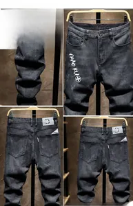Detail of slim fit black denim pants with distressed wash and CHAO KU print on the thigh