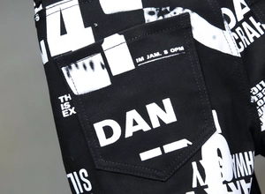 Detailansicht der schwarzen schmalen Hose mit weißen Buchstaben-Prints auf der Gesäßtasche