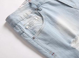 Détail du short en jean bleu clair montrant la texture délavée et le design déchiré