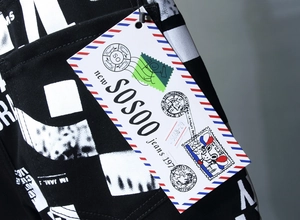 Makroaufnahme von kreativem Etikett und geometrischem Druck auf schmalen schwarzen Jeans