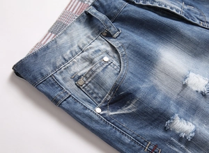 Detailed close-up of blue denim shorts waistband with red plaid lining and metal rivets