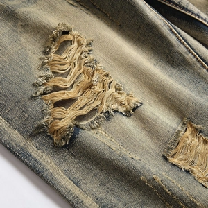 Men's retro loose distressed denim shorts featuring heavy ripped detailing and vintage wash