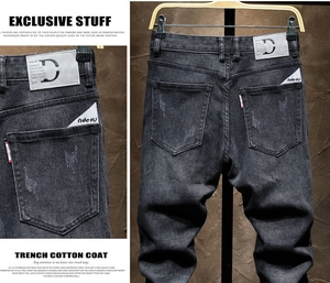 Macro shot of dark grey denim jeans with distressed back pocket and leather patch