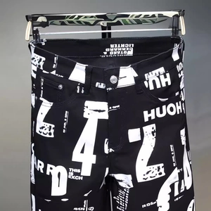 Schmal geschnittene Herrenjeans in Schwarz mit markantem weißem Buchstaben- und Zahlenprint