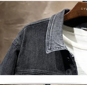 Close-up of black denim jacket showing collar detail, heavy denim texture and stitching