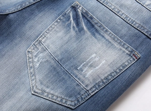 Detailed macro view of denim back pocket with contrast stitching and fading effect