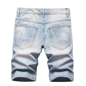 Jeans azzurri con strappi e schizzi di vernice colorati per un look street style maschile
