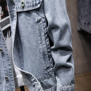 Detail of light blue denim jacket showing flap pockets and premium metal buttons