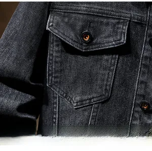 Detail of chest flap pocket on black denim jacket with reinforced double stitching