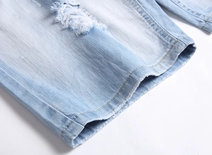Nahaufnahme von Destroyed-Denim-Shorts mit Rissen und klassischen gelben Steppnähten