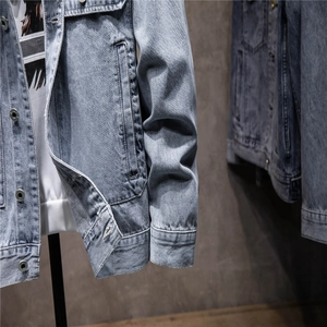 Men's light blue washed denim jacket with metal buttons and chest pockets in a loose fit