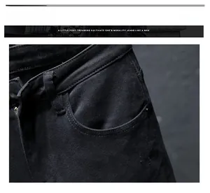 Detail of men's slim black denim jeans showing waist and side pocket with rivets