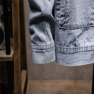 Detailed view of reinforced stitching and light blue washed denim texture on jacket cuff