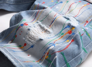 Gros plan d'un short en jean bleu clair délavé avec des éclaboussures de peinture colorées