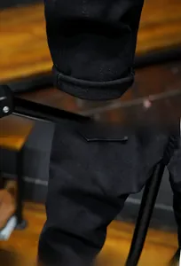 Detailed close-up of the hem design and high-quality cotton fabric of black slim jeans