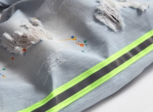 Détails de jeans bleu clair avec taches de peinture et bandes réfléchissantes néon