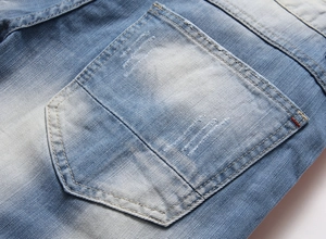 Detailed macro view of denim back pocket with distressed holes and wash effect