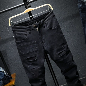 Men's slim fit distressed black jeans with patches and ripped details in street style