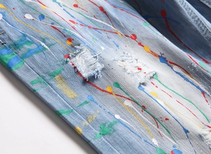 Détail d'un short en jean bleu clair avec éclaboussures de peinture et effets déchirés