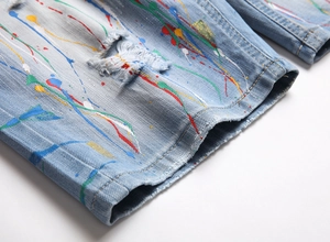 Gros plan sur un short en jean bleu clair avec éclaboussures de peinture et détails déchirés
