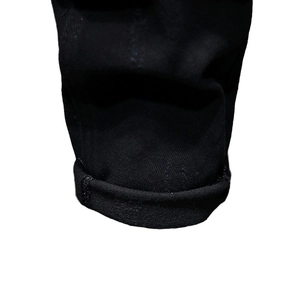 Men's slim fit distressed black denim jeans featuring folded cuffs and thick cotton fabric