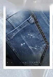 Detail of dark blue denim shorts featuring paint splatter finish and reinforced back pocket