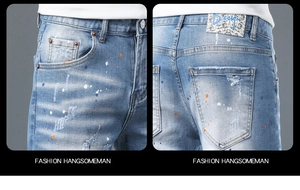 Detail of light blue denim shorts with artistic paint splatters and distressed holes