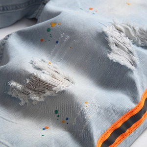 Jeans dritti azzurri con strappi consumati, macchie di vernice e nastri laterali