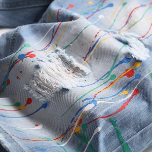Short en jean hip-hop pour hommes avec trous déchirés et design de peinture éclaboussée