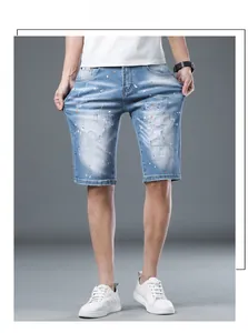 Detailed view of light blue distressed denim shorts featuring paint splatter and ripped details