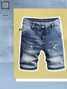 Detail of blue denim shorts featuring white paint splatter and a zipper fly closure
