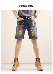 Detailed close-up of dark blue denim shorts featuring artistic colorful paint splatter design