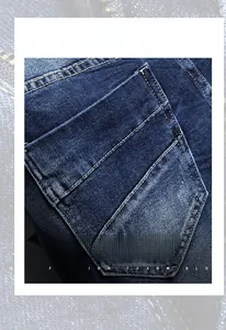 Detail view of washed blue denim shorts showing double stitching and pocket texture