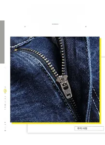 Detailed close-up showing high-quality YKK metal zipper on blue denim shorts for men