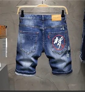 Detail der chinesischen Stickerei auf blauen Denim-Shorts mit Leder-Taillenpatch