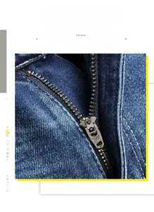 Detail shot of a high-quality YKK metal zipper on washed blue stretch denim shorts