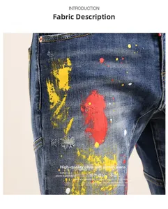 Close-up of blue denim shorts with artistic paint splatters and worn hole details
