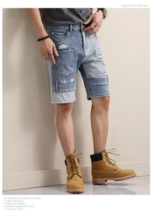 Detailed close-up of patched denim shorts with distressed texture and frayed edge finish