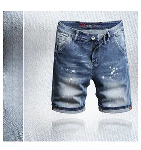 Detail of slim fit men's denim shorts with paint splatter and vintage wash effect
