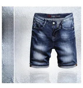 Detail of slim fit men's blue denim shorts showing washed texture and cuffed hem