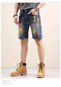 Detailed view of dark blue denim shorts with artistic paint splatter and street style design