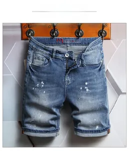 Detailed shot of retro blue men's denim shorts with white paint splatters and cuffed hems