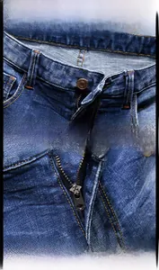 Detail von Kupferknopf und Metallreißverschluss an blauen Denim-Shorts mit Kontrastnaht