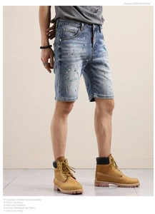 Détail du short en jean bleu avec éclaboussures de peinture et texture délavée vintage