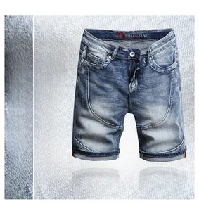 Detail of slim fit denim shorts with washed cat whiskers and curved seam stitching