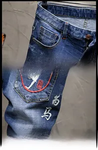 Detail der dunkelblauen Denim-Shorts mit Stickerei und Distressed-Wascheffekt