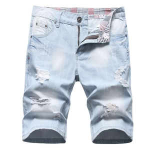 Detail of ripped blue denim shorts with vintage wash and stylish plaid waist lining